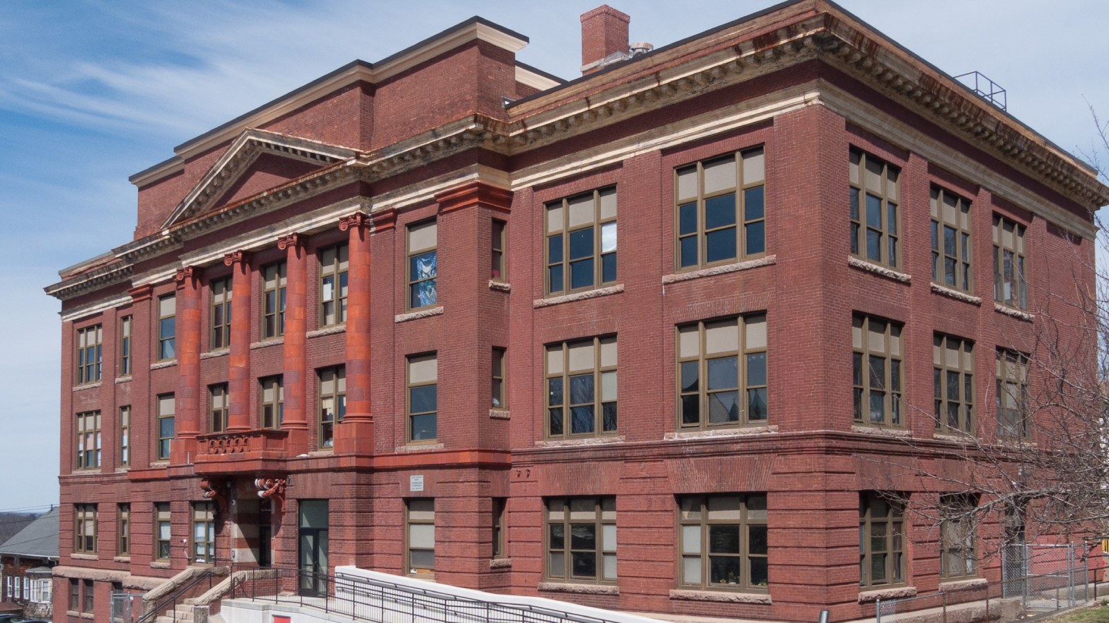 The four-story red brick Westall School in Fall River, with columns over the front entrance and a ramp leading to the doors