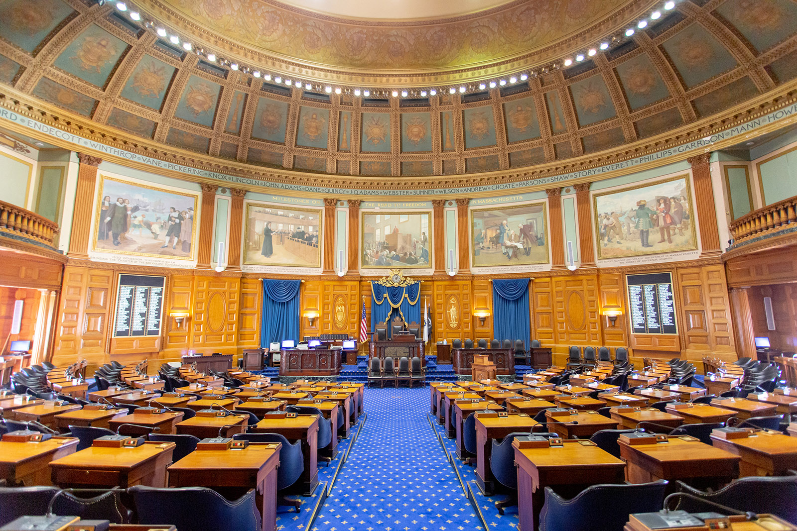 The Massachusetts House of Representatives chamber, where the Legislature meets, with rows of members' desks beneath a painted ceiling