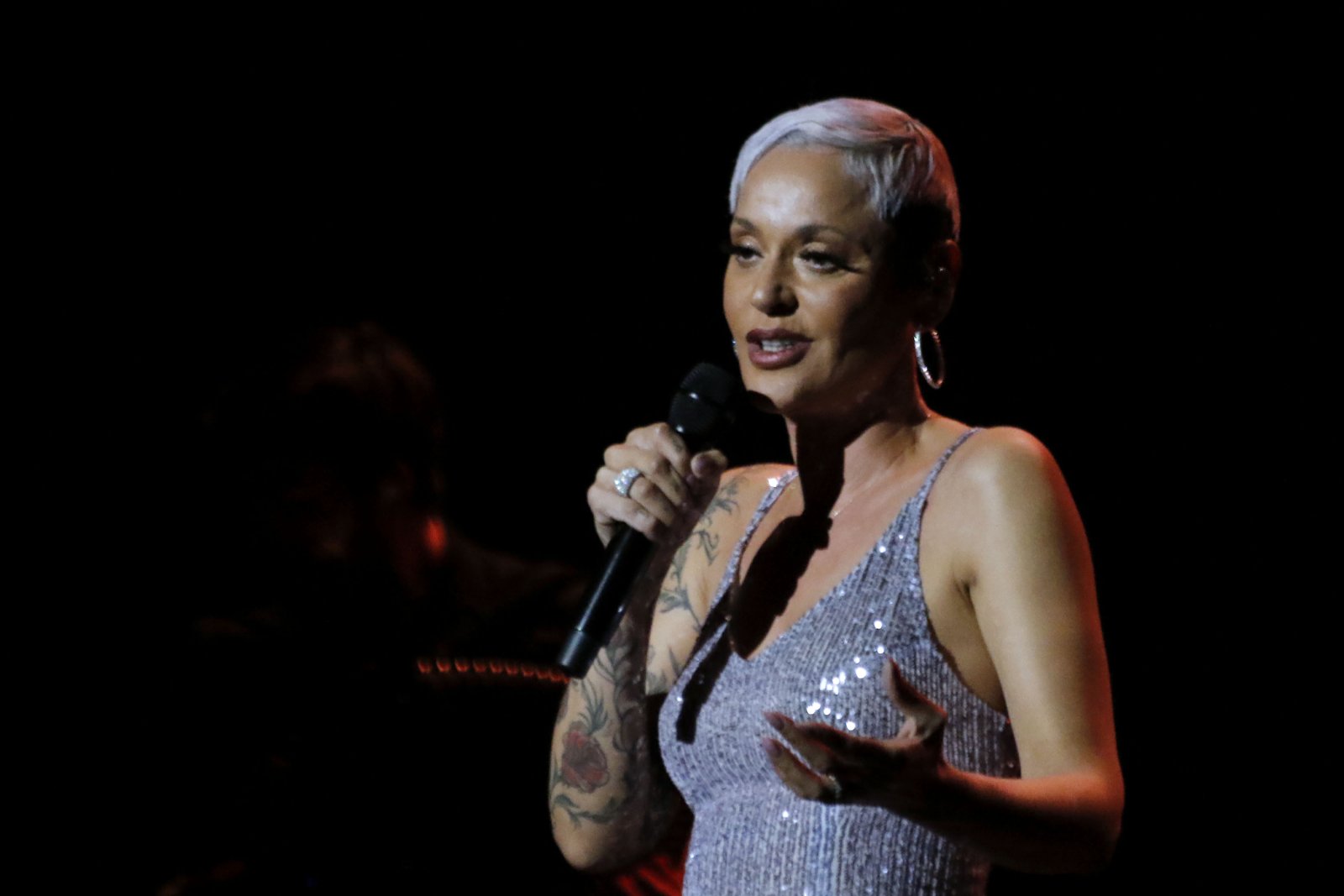 Mariza, the Portuguese fado singer who returns to the Zeiterion Performing Arts Center on Friday, singing into a handheld microphone in concert
