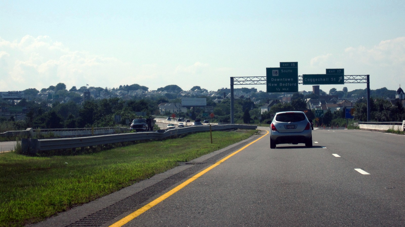 Interstate 195 westbound in New Bedford, with an overhead sign for the Route 18 South, Downtown New Bedford exit in half a mile and a Coggeshall Street exit sign