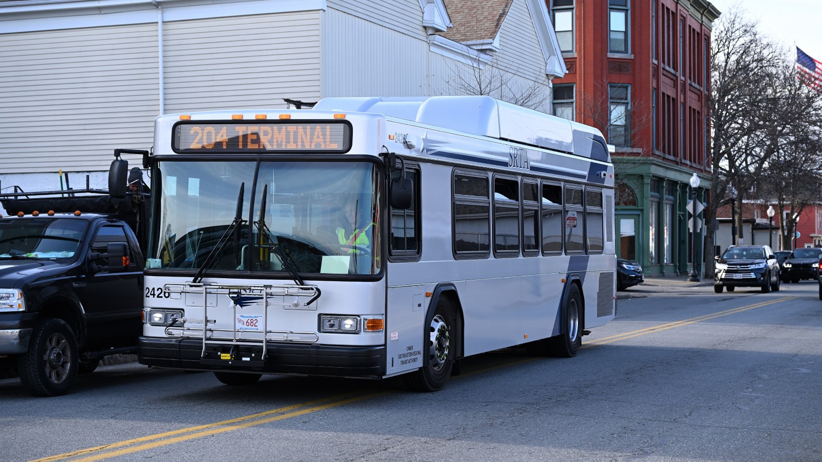 A silver SRTA bus showing 204 Terminal on its sign drives down Purchase Street in New Bedford