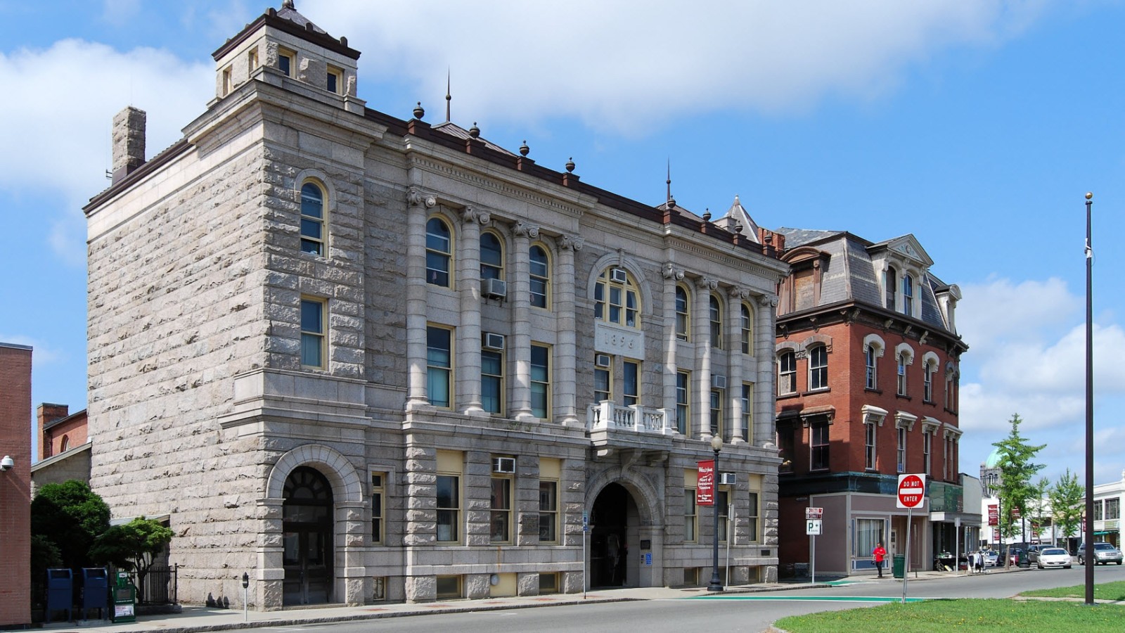 Taunton City Hall, a three-story granite building with arched windows and 1896 carved above the balcony, beside the brick Leonard Block on Summer Street