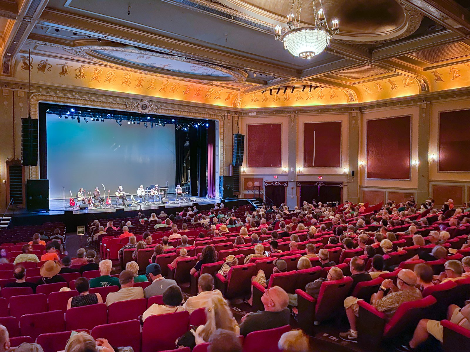 The auditorium of the Zeiterion Performing Arts Center on Purchase Street in New Bedford, with an audience in red seats facing the stage under a chandelier