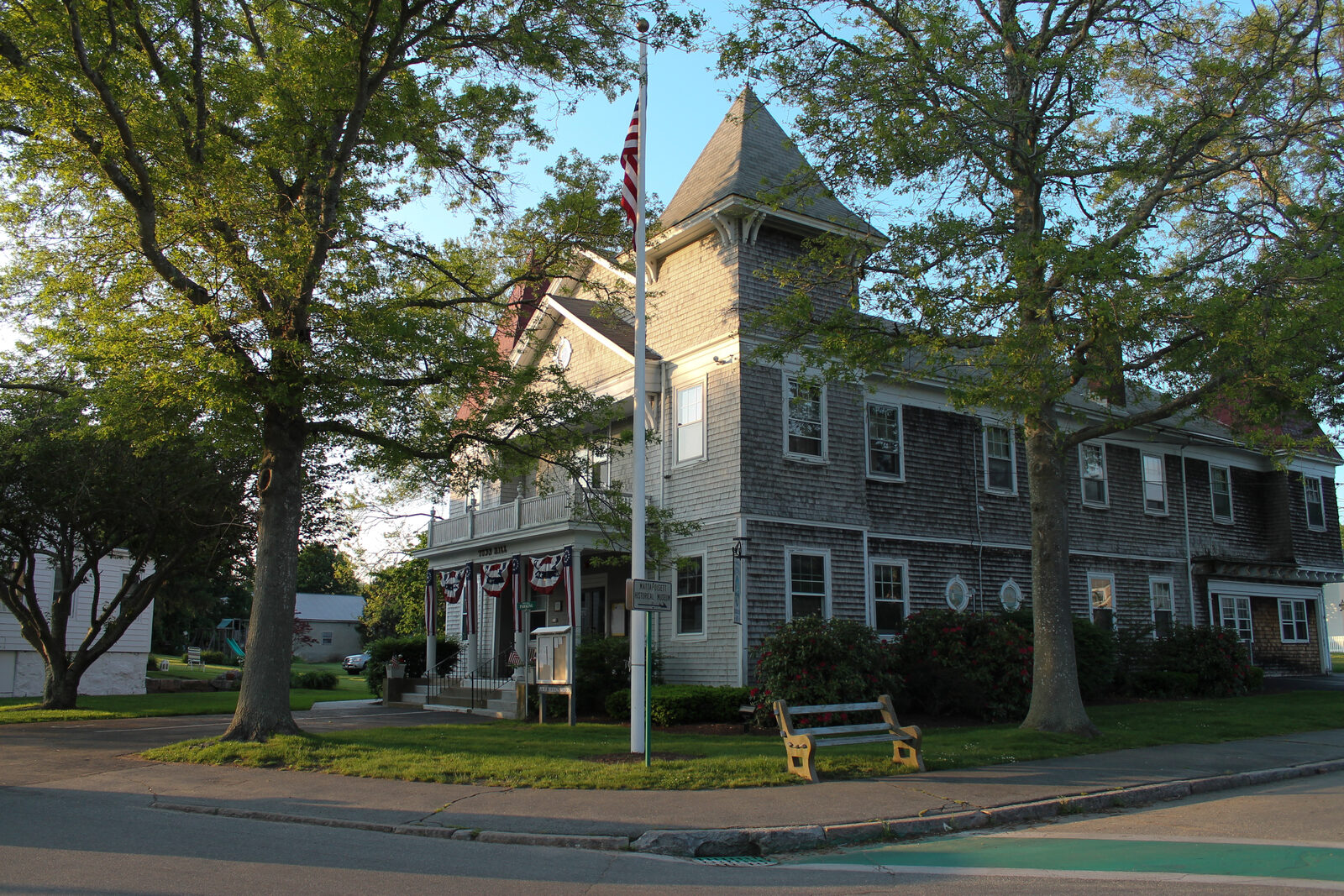 Mattapoisett Town Hall, a shingled building with a corner tower among shade trees