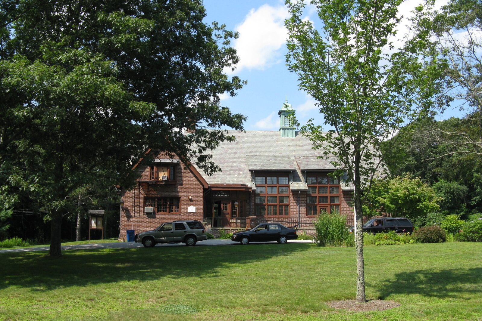 Goff Memorial Hall, a brick and shingle hall behind a lawn in Rehoboth
