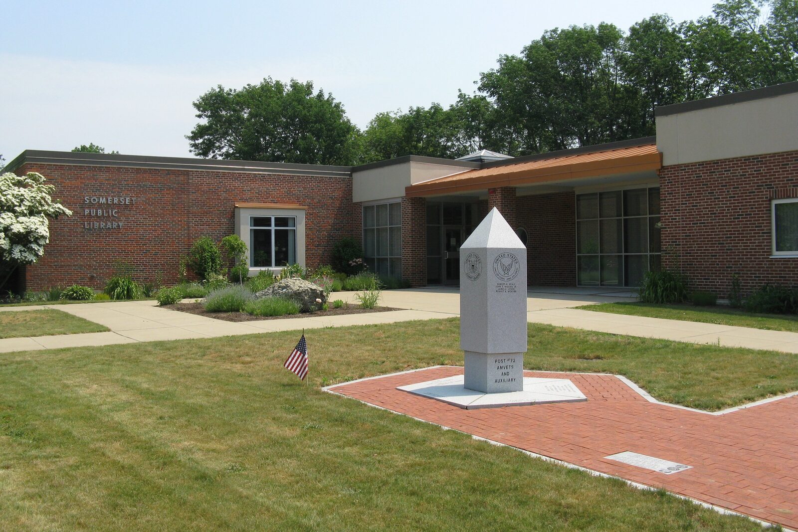 Somerset Public Library, a low brick building with a stone monument on the lawn