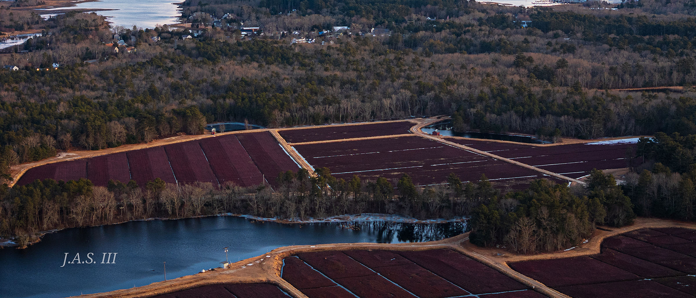 Cranberry bogs and a bay at sunset, seen from the air