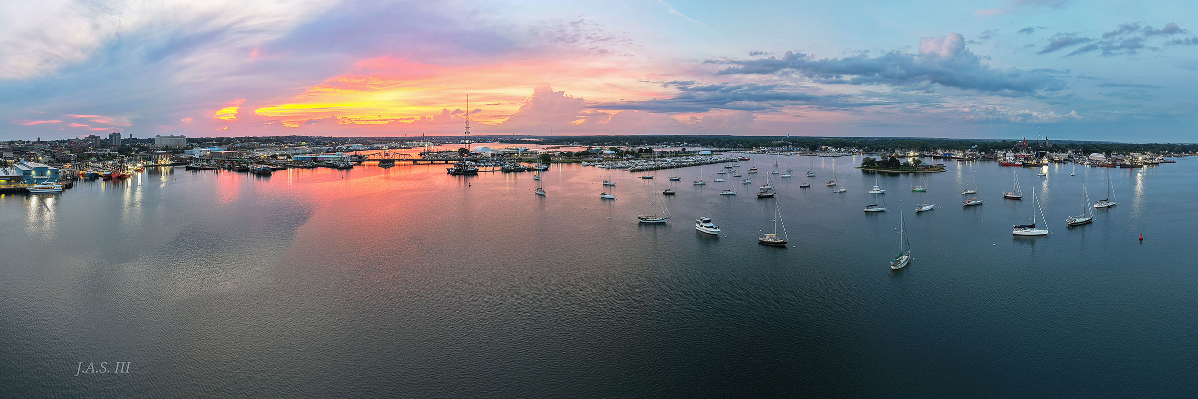 Harbor moorings under a pink and orange sunset sky