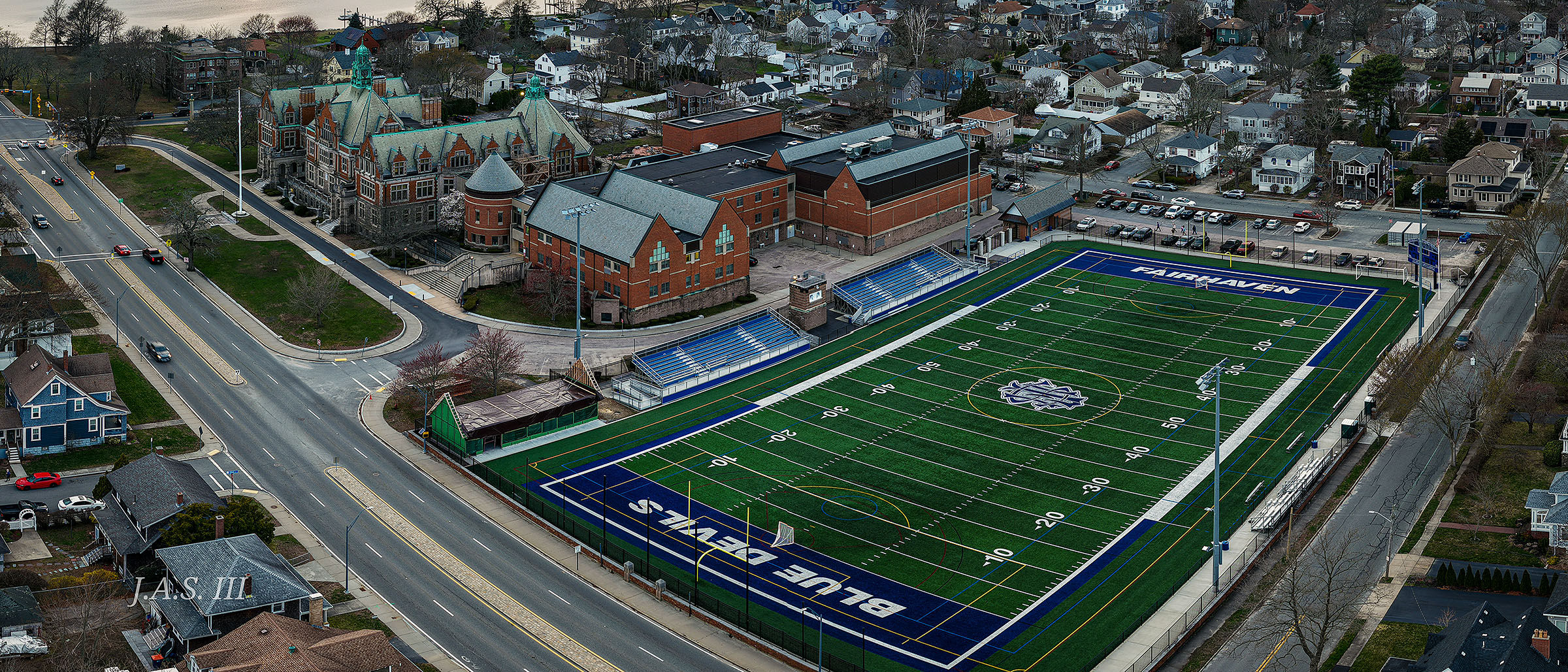 Aerial view of a high school and its football field at sunset